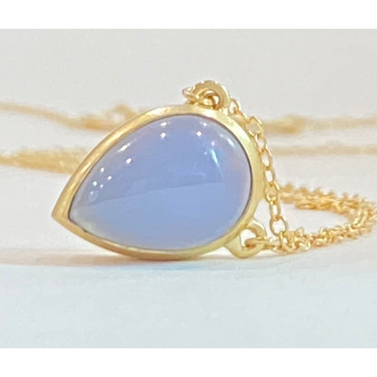 Keep your loved ones close to your heart with our cremation illumination Necklace . Crafted with care, this necklace allows you to carry a small portion of their ashes, providing comfort and a constant reminder of their presence.. Pendant 15mm long x 10 mm wide Handmade clasp Chain with Clasp 16 inch long. 14k Yellow Gold Stone Chalcedony